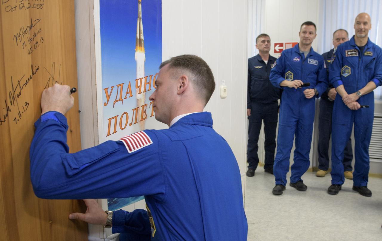 Expedition 59 astronaut Nick Hague of NASA signs a door in the Cosmonaut Hotel prior to departing for launch on a Soyuz rocket with Christina Koch of NASA, and Alexey Ovchinin of Roscosmos, Thursday, March 14, 2019 in Baikonur, Kazakhstan. Hague, Koch, and Ovchinin will launch March 14, U.S. time, on the Soyuz MS-12 spacecraft from the Baikonur Cosmodrome for a six-and-a-half month mission on the International Space Station. Photo Credit: (NASA/Bill Ingalls)