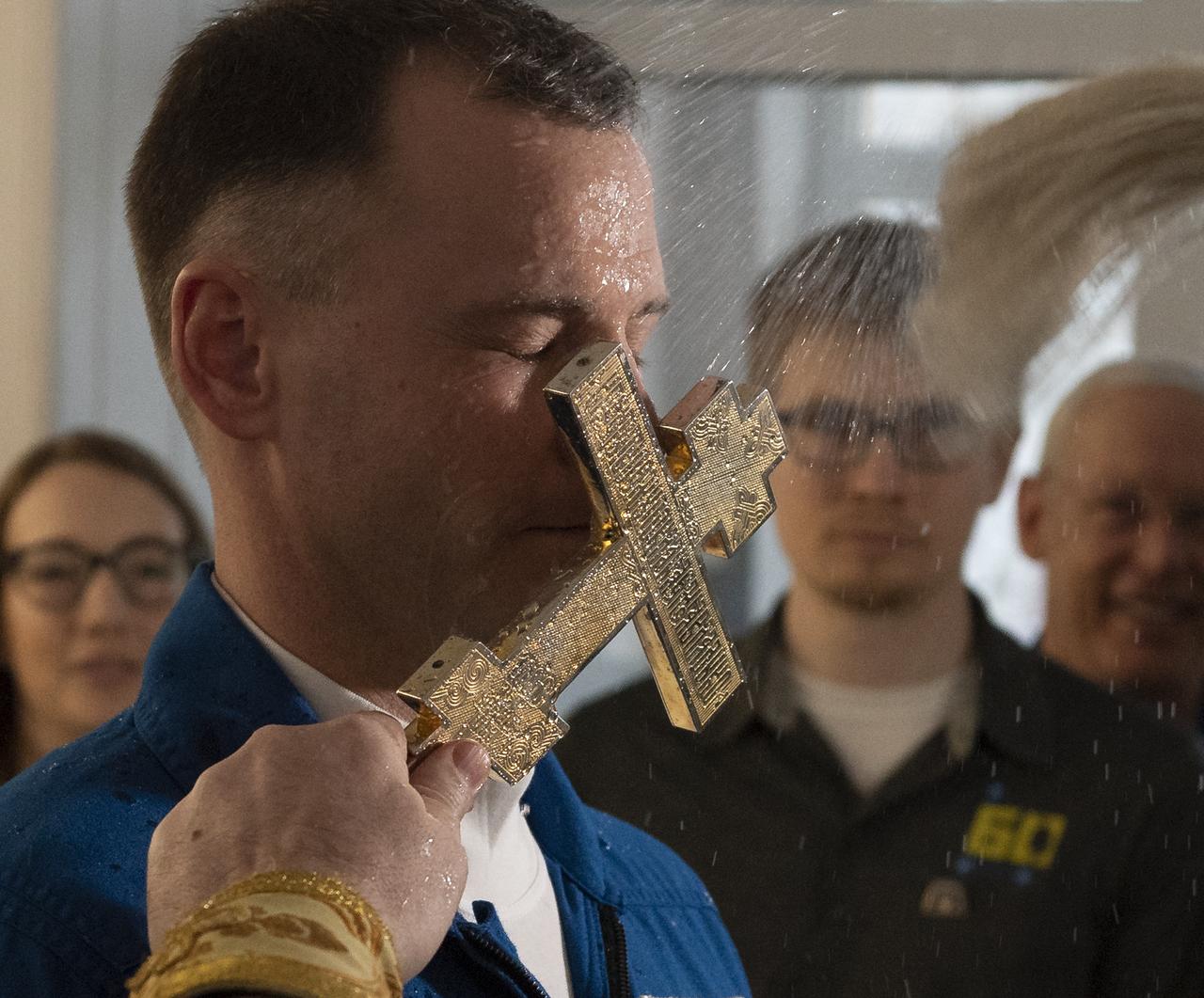 Expedition 59 astronaut Nick Hague of NASA is blessed by a Russian Orthodox Priest in the Cosmonaut Hotel prior to departing for launch on a Soyuz rocket with Alexey Ovchinin of Roscosmos, and Christina Koch of NASA, Thursday, March 14, 2019 in Baikonur, Kazakhstan. Hague, Koch, and Ovchinin will launch March 14, U.S. time, on the Soyuz MS-12 spacecraft from the Baikonur Cosmodrome for a six-and-a-half month mission on the International Space Station. Photo Credit: (NASA/Bill Ingalls)