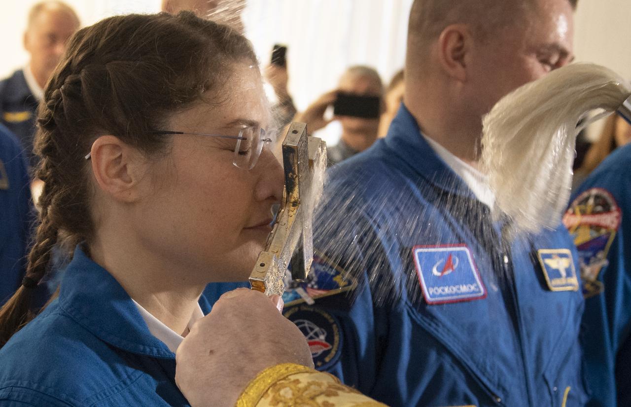 Expedition 59 astronaut Christina Koch of NASA is blessed by a Russian Orthodox Priest in the Cosmonaut Hotel prior to departing for launch on a Soyuz rocket with Nick Hague of NASA, and Alexey Ovchinin of Roscosmos, Thursday, March 14, 2019 in Baikonur, Kazakhstan. Hague, Koch, and Ovchinin will launch March 14, U.S. time, on the Soyuz MS-12 spacecraft from the Baikonur Cosmodrome for a six-and-a-half month mission on the International Space Station. Photo Credit: (NASA/Bill Ingalls)