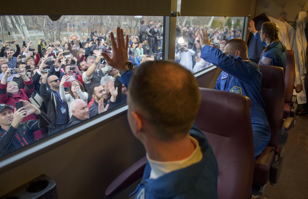 Expedition 59 astronaut Nick Hague of NASA, left, Alexey Ovchinin of Roscosmos, center, and Christina Koch of NASA wave farewell to friends and family as they depart the Cosmonaut Hotel ahead of their launch on a Soyuz rocket, Thursday, March 14, 2019 at the Baikonur Cosmodrome in Kazakhstan. Hague, Koch, and Ovchinin launched on the Soyuz MS-12 spacecraft from the Baikonur Cosmodrome for a six-and-a-half month mission on the International Space Station. Photo Credit: (NASA/GCTC/Irina Spector)