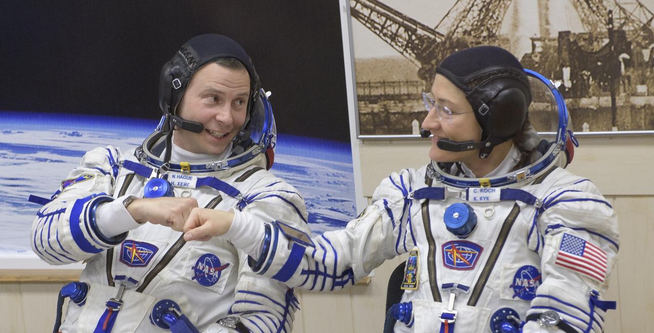 Expedition 59 astronaut Nick Hague and Christina Koch of NASA fist pump while getting their Sokol suit pressure checked prior to launch on a Soyuz rocket with Alexey Ovchinin of Roscosmos, Thursday, March 14, 2019 at the Baikonur Cosmodrome in Kazakhstan. Hague, Koch, and Ovchinin launched March 14, U.S. time, on the Soyuz MS-12 spacecraft from the Baikonur Cosmodrome for a six-and-a-half month mission on the International Space Station. Photo Credit: (NASA/Bill Ingalls)