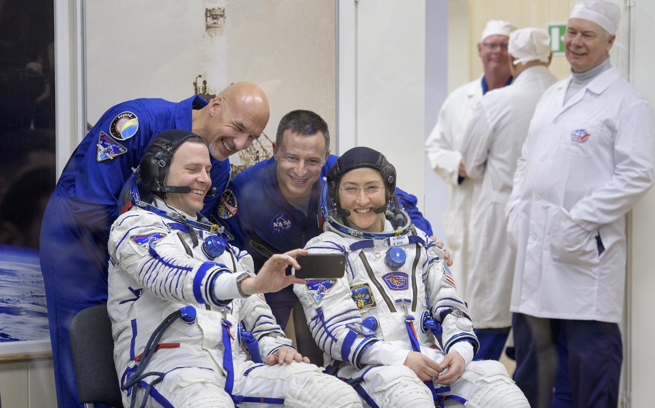 Expedition 59 astronaut Nick Hague and Christina Koch of NASA, seated, make photograph with Expedition 59 backup crewmembers Luca Parmitano of the European Space Agency, left, and Drew Morgan of NASA during Sokol suit pressure checks prior to launch on a Soyuz rocket with Alexey Ovchinin of Roscosmos, Thursday, March 14, 2019 at the Baikonur Cosmodrome in Kazakhstan. Hague, Koch, and Ovchinin launched March 14, U.S. time, on the Soyuz MS-12 spacecraft from the Baikonur Cosmodrome for a six-and-a-half month mission on the International Space Station. Photo Credit: (NASA/Bill Ingalls)