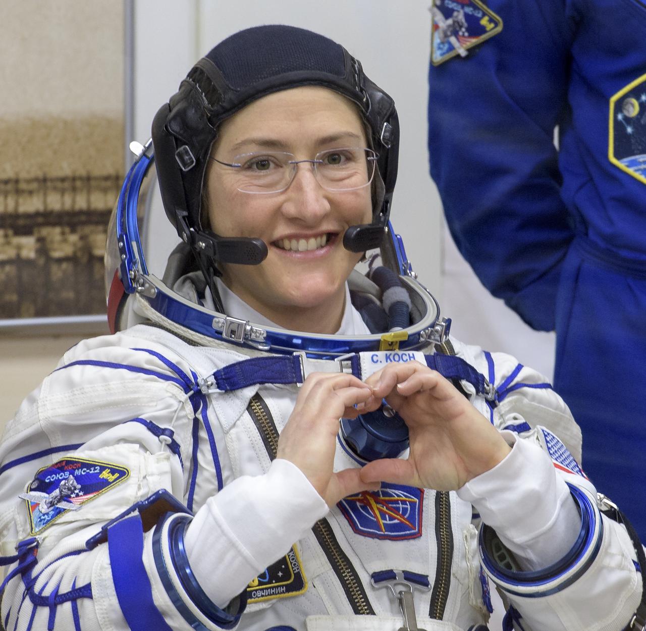 Expedition 59 astronaut Christina Koch of NASA gestures to family and friends as she waits to have her Sokol suit pressure checked prior to her launch on a Soyuz rocket with Nick Hague of NASA and Alexey Ovchinin of Roscosmos, Thursday, March 14, 2019 at the Baikonur Cosmodrome in Kazakhstan. Hague, Koch, and Ovchinin launched March 14, U.S. time, on the Soyuz MS-12 spacecraft from the Baikonur Cosmodrome for a six-and-a-half month mission on the International Space Station. Photo Credit: (NASA/Bill Ingalls)