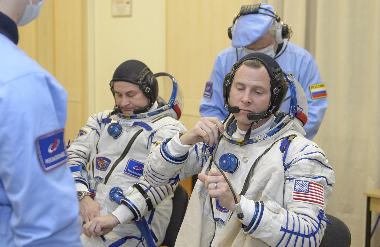 Expedition 59 cosmonaut Alexey Ovchinin of Roscosmos, left, and Nick Hague of NASA don their Sokol suits prior to their launch on a Soyuz rocket with Christina Koch of NASA, Thursday, March 14, 2019 at the Baikonur Cosmodrome in Kazakhstan. Hague, Koch, and Ovchinin launched March 14, U.S. time, on the Soyuz MS-12 spacecraft from the Baikonur Cosmodrome for a six-and-a-half month mission on the International Space Station Photo Credit: (NASA/GCTC/Irina Spector)
