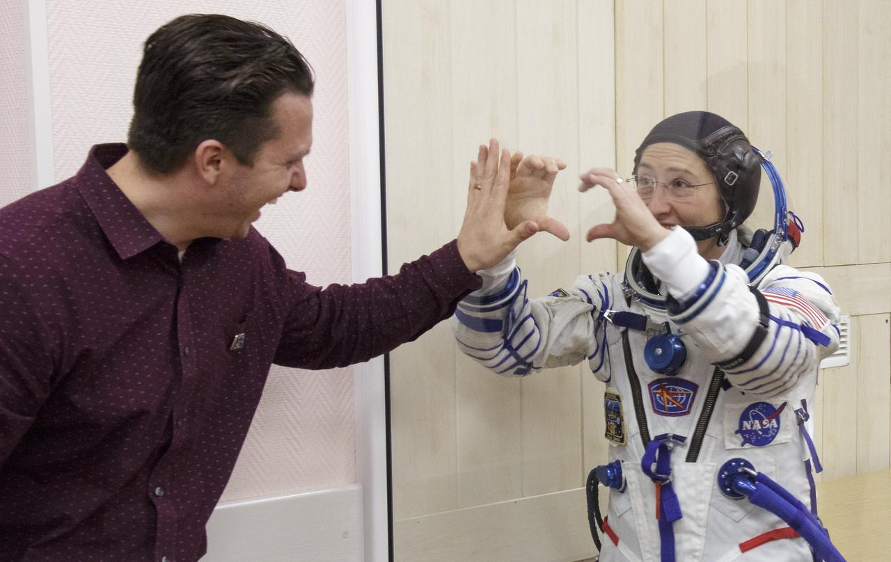 Expedition 59 astronaut Christina Koch of NASA, in quarantine, places her hands up against the glass as her husband Robert does the same prior her departing building 254 for the launch pad with Alexey Ovchinin of Roscosmos and Nick Hague of NASA, Thursday, March 14, 2019 at the Baikonur Cosmodrome in Kazakhstan. Hague, Koch, and Ovchinin launched March 14, U.S. time, on the Soyuz MS-12 spacecraft from the Baikonur Cosmodrome for a six-and-a-half month mission on the International Space Station. Photo Credit: (NASA/Victor Zelentsov)