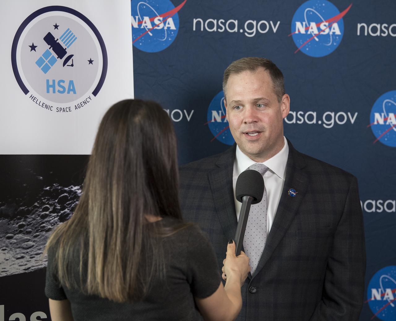 NASA Administrator Jim Bridenstine, is interviewed by Greek television after he signed a joint statement with the Hellenic Space Agency (HSA) CEO, Dr. Georgios Mantzouris, at the Space Symposium, Monday, April 8, 2019 in Colorado Springs, Colorado. Dr. Mantzouris expressed a desire to remain open to opportunities for collaboration, both through Greece’s contributions to the European Space Agency, of which it has been a member since 2005, and bilaterally. Photo Credit: (NASA/Aubrey Gemignani)