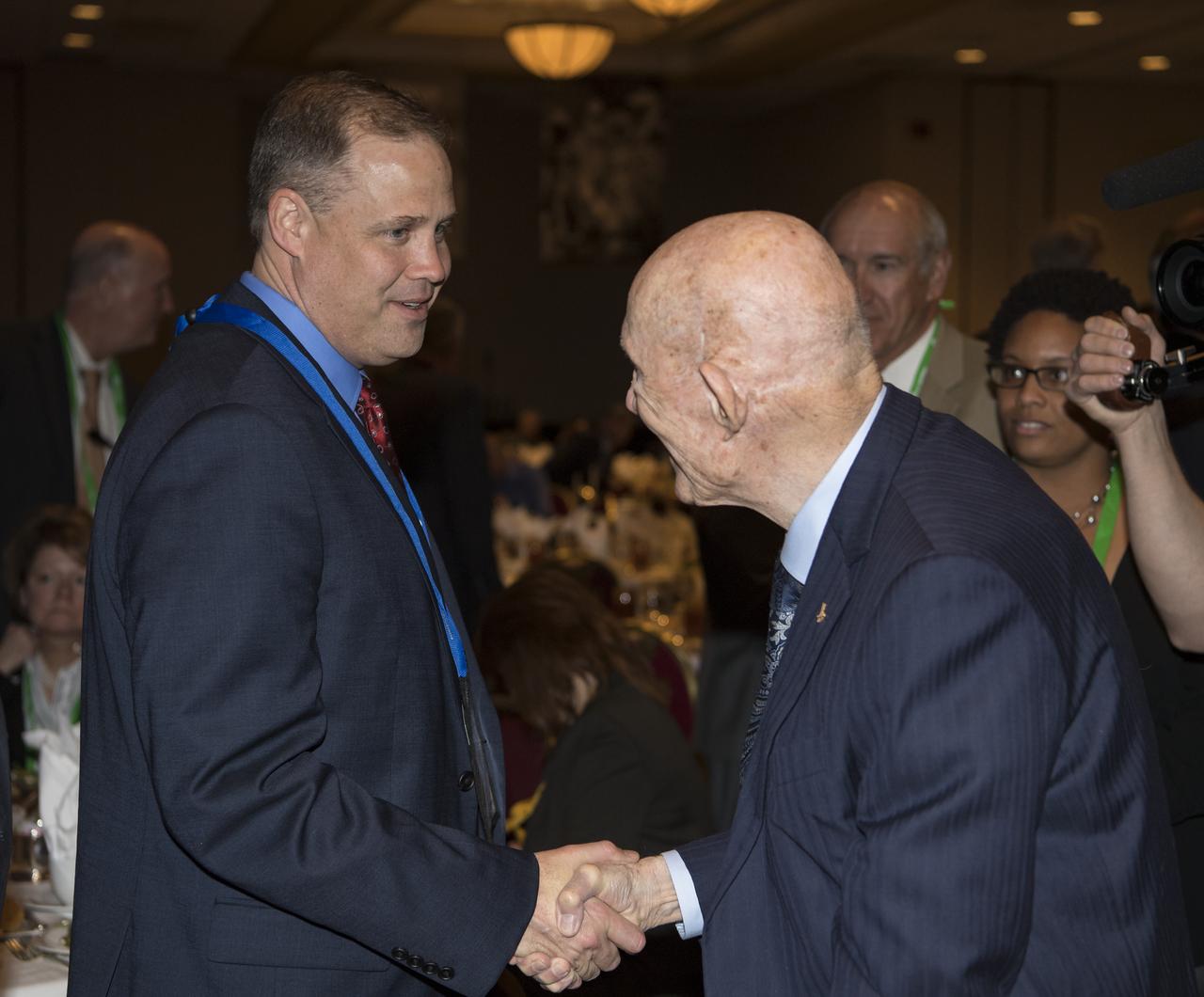 General Thomas Stafford, former NASA astronaut, Air Force officer and test pilot, right, shakes hands with NASA Administrator Jim Bridenstine at an event where General Stafford was awarded the General James E. Hill Lifetime Achievement Award, at the Space Symposium, Tuesday, April 9, 2019, at Broadmoor Hall in Colorado Springs, Colorado. Former and current NASA Administrators were in attendance. Photo credit: (NASA/Aubrey Gemignani)