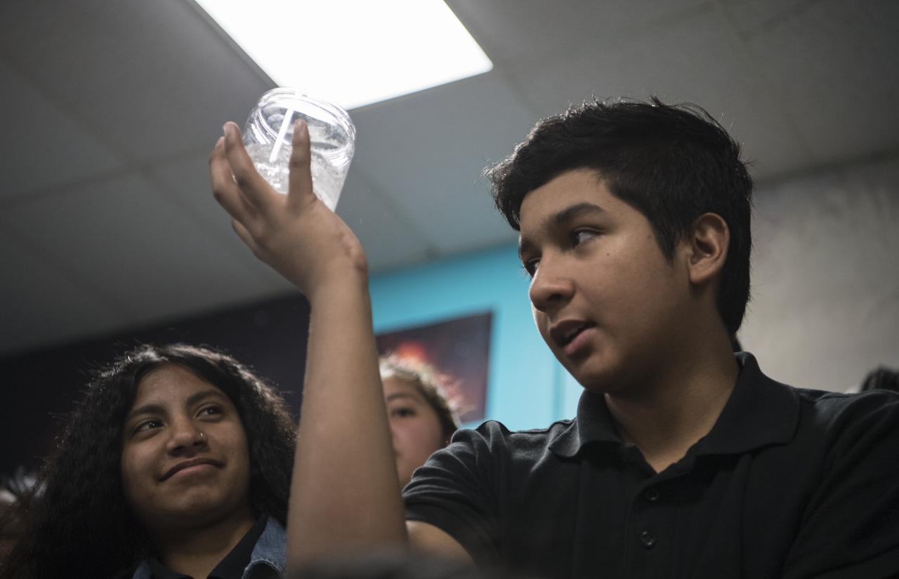 A student holds up a glass of water with an Alka-Seltzer tab in it while conducting an experiment on effervescence, Friday, May 3, 2019 at the Challenger Center in Lanham, MD. NASA astronaut Ricky Arnold helped them carry out the experiment which he also conducted during his 197 day mission onboard the International Space Station (ISS) during Expeditions 55/56. Photo Credit: (NASA/Aubrey Gemignani)