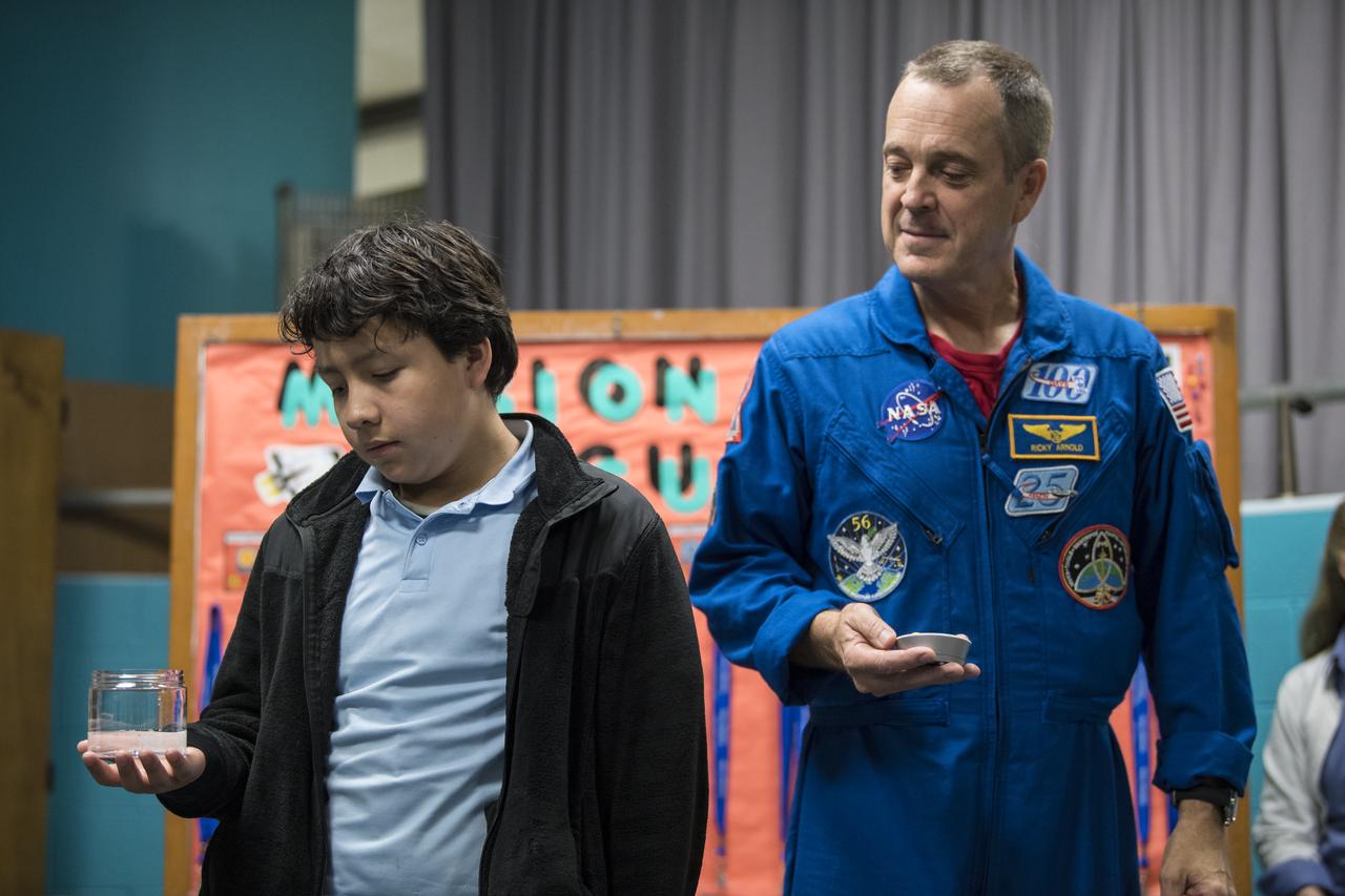 NASA astronaut Ricky Arnold watches a timer while students conduct an experiment on effervescence, Friday, May 3, 2019 at the Challenger Center in Lanham, MD. During Expedition 55/56, Arnold completed three spacewalks for a total of 19.5 hours outside the International Space Station (ISS), and concluded his 197 day mission when he landed in a remote area near the town of Zhezkazgan, Kazakhstan in Oct. 2018. He also flew to the space station on shuttle mission STS-119 to deliver the final pair of power-generating solar array wings. Photo Credit: (NASA/Aubrey Gemignani)