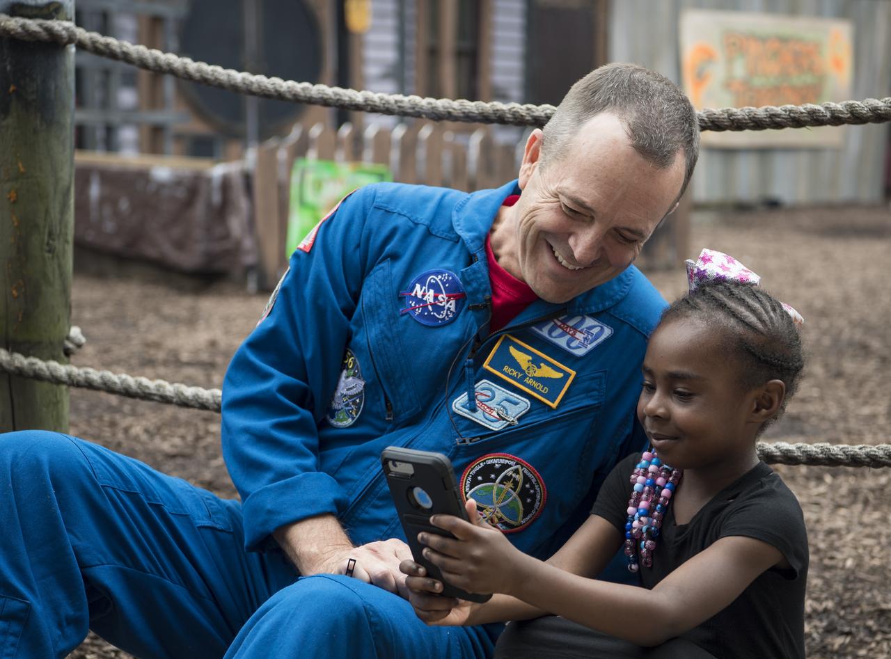 NASA astronaut Ricky Arnold poses for a selfie with an audience member after speaking about his time onboard the International Space Station (ISS) during a Smithsonian National Air and Space Museum production of Stem in 30, Friday, May 3, 2019 at Six Flags America theme park in Upper Marlboro, MD. During Expedition 55/56, Arnold completed three spacewalks for a total of 19.5 hours outside the space station, and concluded his 197 day mission when he landed in a remote area near the town of Zhezkazgan, Kazakhstan in Oct. 2018. He also flew to the space station on shuttle mission STS-119 to deliver the final pair of power-generating solar array wings. Photo Credit: (NASA/Aubrey Gemignani)