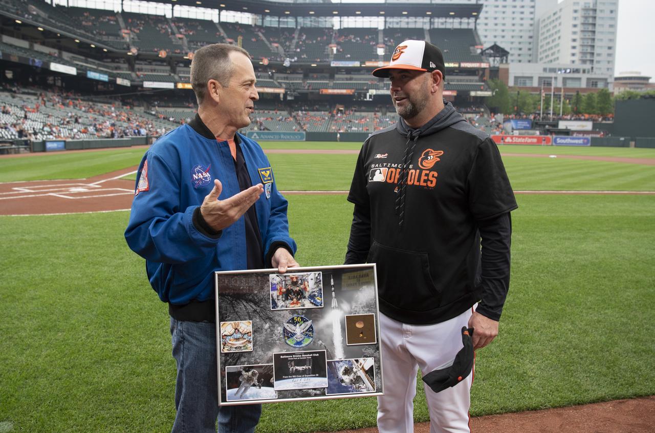 NASA astronaut and Maryland native Ricky Arnold talks with Baltimore Orioles manager Brandon Hyde after presenting a montage of images from his mission and a Baltimore Orioles hat that was flown aboard the International Space Station before the Tampa Bay Rays take on the Baltimore Orioles, Saturday, May 4, 2019 at Camden Yards in Baltimore, Md. During Arnold’s 197 days onboard the International Space Station, as part of Expeditions 55 and 56, he ventured outside the space station on three spacewalks in addition to conducting numerous experiments and educational downlink events. Photo Credit: (NASA/Joel Kowsky)