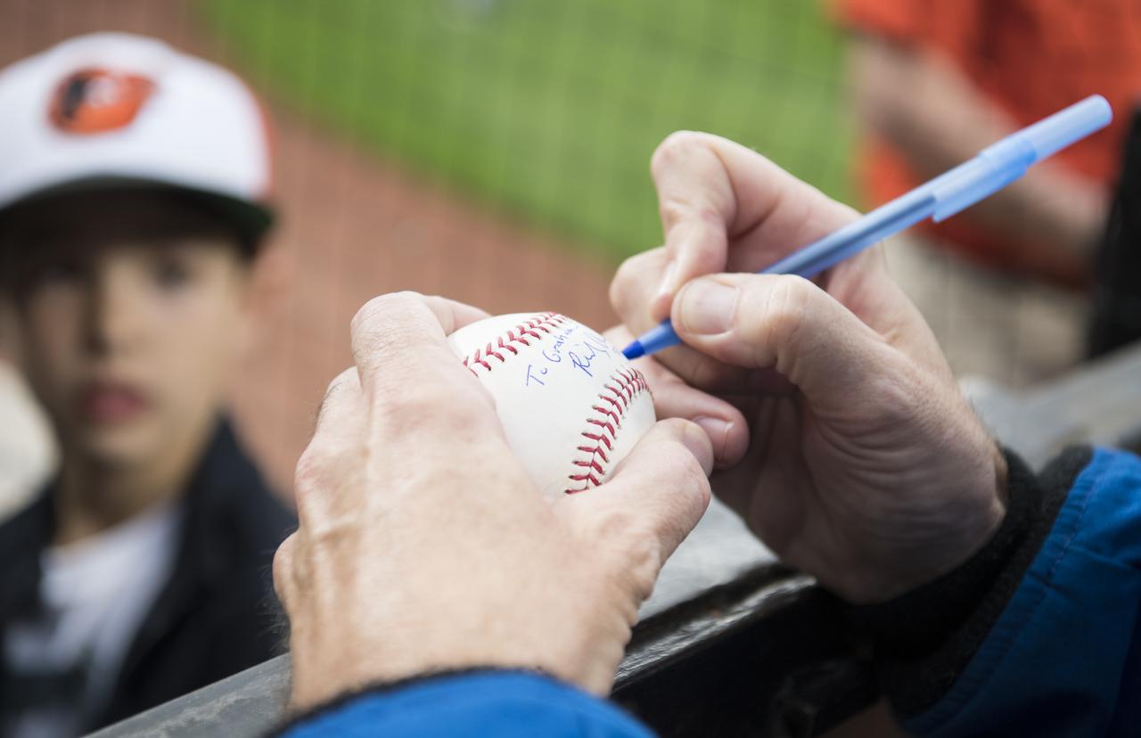 NASA astronaut and Maryland native Ricky Arnold signs a baseball for a young fan before the Tampa Bay Rays take on the Baltimore Orioles, Saturday, May 4, 2019 at Camden Yards in Baltimore, Md. During Arnold’s 197 days onboard the International Space Station, as part of Expeditions 55 and 56, he ventured outside the space station on three spacewalks in addition to conducting numerous experiments and educational downlink events. Photo Credit: (NASA/Joel Kowsky)