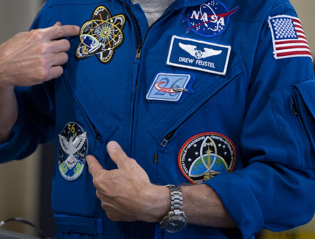NASA astronaut Drew Feustel points to mission patches on his flight suit as he speaks to students at John Burroughs Elementary School about his experiences on two space shuttle missions, STS-125 and STS-134, and a long duration mission onboard the International Space Station, Tuesday, May 7, 2019 in Washington, DC. Feustel most recently spent 197 days living and working onboard the International Space Station as part of Expedition 55 and as commander of Expedition 56. Feustel ventured outside the space station on three spacewalks, moving him up to second among U.S. spacewalkers with a cumulative time of 61 hours 48 minutes over nine spacewalks. Photo Credit: (NASA/Joel Kowsky)