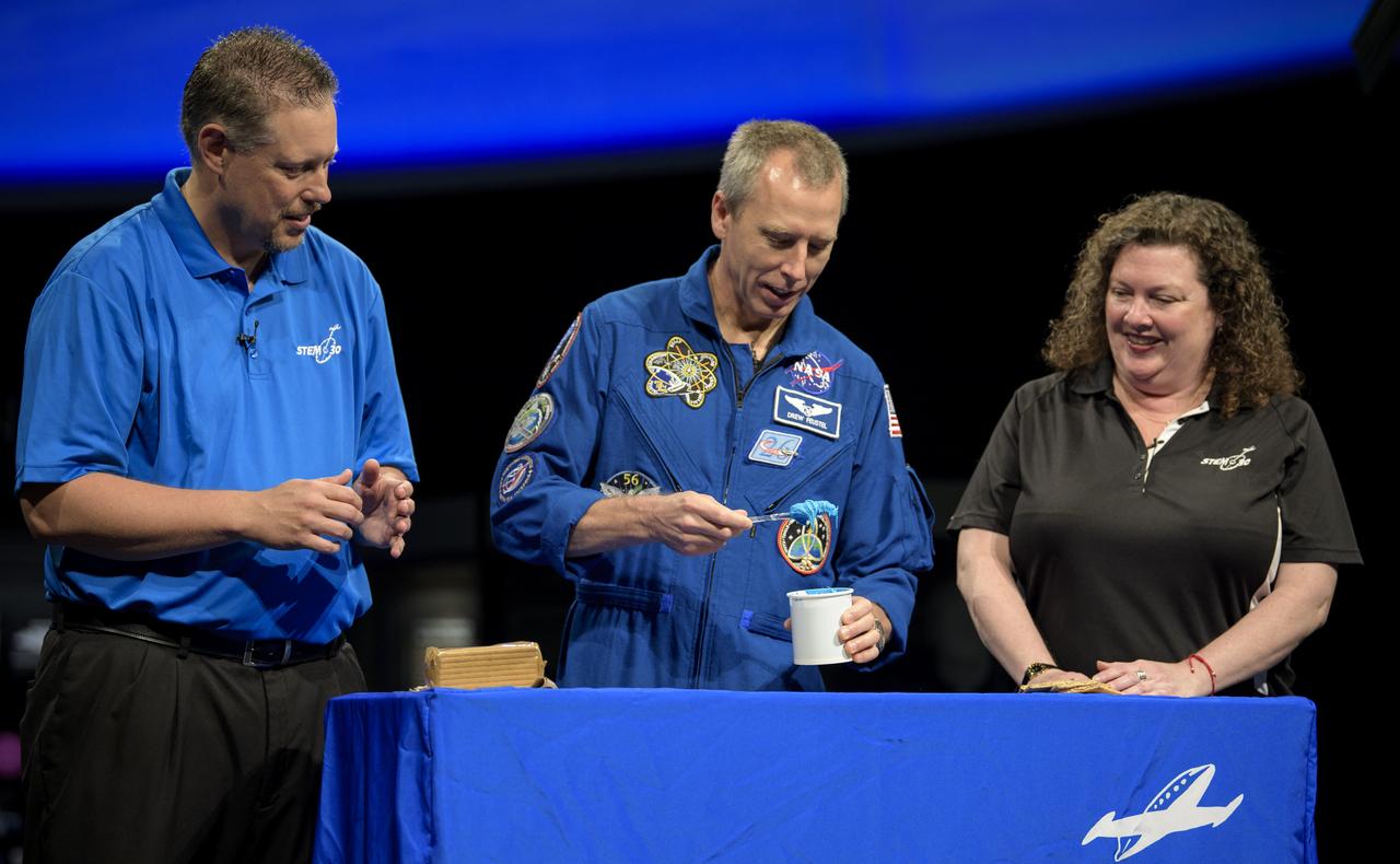 NASA astronaut Drew Feustel, center, uses frosting and graham crackers to represent the layers of Earths crust while taping a segment of STEM in 30 with Marty Kelsey, left, and Beth Wilson, right, Thursday, May 9, 2019 at the Smithsonian’s National Air and Space Museum in Washington, DC. Feustel most recently spent 197 days living and working onboard the International Space Station as part of Expedition 55 and as commander of Expedition 56. Feustel ventured outside the space station on three spacewalks, moving him up to second among U.S. spacewalkers with a cumulative time of 61 hours 48 minutes over nine spacewalks. Photo Credit: (NASA/Joel Kowsky)