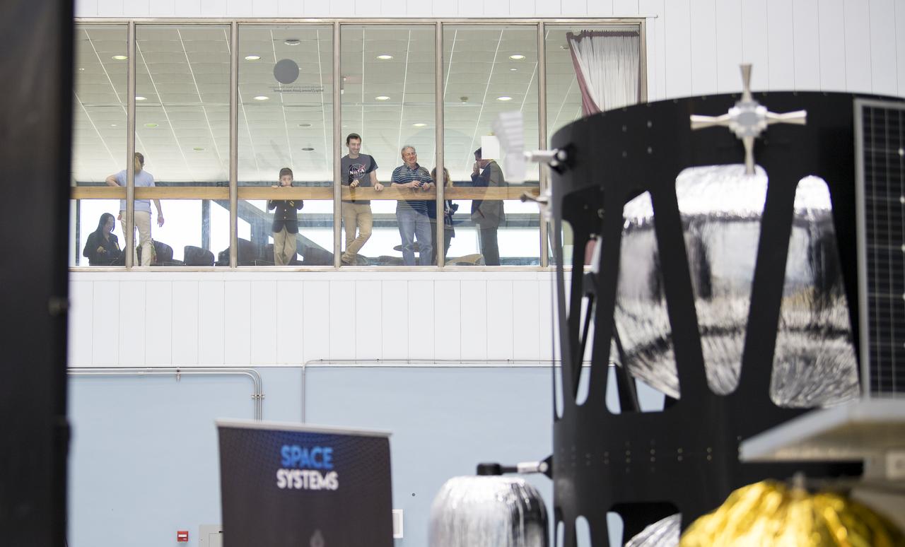 Goddard Space Flight Center employees are seen looking at the lunar landers from above, Friday, May 31, 2019, at Goddard Space Flight Center in Md. Astrobotic, Intuitive Machines, and Orbit Beyond have been selected to provide the first lunar landers for the Artemis program's lunar surface exploration. Photo credit: (NASA/Aubrey Gemignani)
