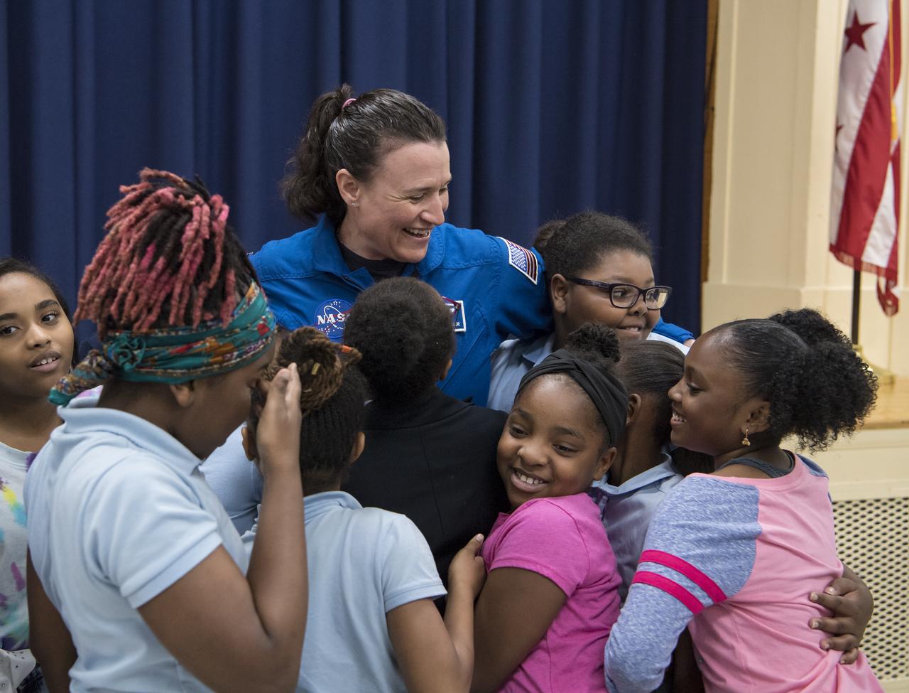 NASA astronaut Dr. Serena Auñón-Chancellor is hugged by students after a presentation about her experience on Expeditions 56 and 57 onboard the International Space Station (ISS) at Excel Academy Public Charter School, Monday, June 10, 2019 in Washington, DC. Auñón-Chancellor spent 197 days living and working onboard the ISS and contributed to hundreds of experiments in biology, biotechnology, physical science, and Earth science while there. She is also a doctor and started her career with NASA as a flight surgeon in 2006. Photo Credit: (NASA/Aubrey Gemignani)