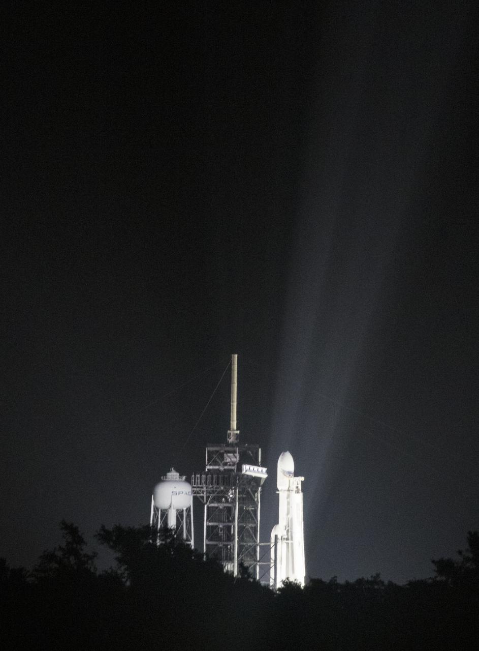 A SpaceX Falcon Heavy rocket carrying 24 satellites as part of the Department of Defense's Space Test Program-2 (STP-2) mission is seen illuminated by lights at Launch Complex 39A, Monday, June 24, 2019 at NASA's Kennedy Space Center in Florida. Four NASA technology and science payloads which will study non-toxic spacecraft fuel, deep space navigation, "bubbles" in the electrically-charged layers of Earth's upper atmosphere, and radiation protection for satellites are among the two dozen satellites that will be launched. The three hour launch window opens at 11:30pm EDT on June 24. Photo Credit: (NASA/Joel Kowsky)