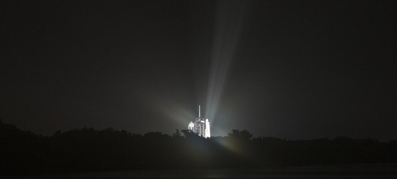 A SpaceX Falcon Heavy rocket carrying 24 satellites as part of the Department of Defense's Space Test Program-2 (STP-2) mission is seen illuminated by lights at Launch Complex 39A, Monday, June 24, 2019 at NASA's Kennedy Space Center in Florida. Four NASA technology and science payloads which will study non-toxic spacecraft fuel, deep space navigation, "bubbles" in the electrically-charged layers of Earth's upper atmosphere, and radiation protection for satellites are among the two dozen satellites that will be launched. The three hour launch window opens at 11:30pm EDT on June 24. Photo Credit: (NASA/Joel Kowsky)