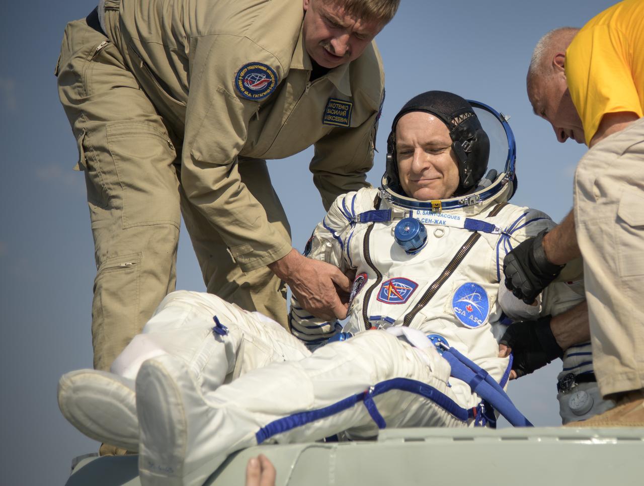 Expedition 59 astronaut David Saint-Jacques of the Canadian Space Agency (CSA) is helped out of the Soyuz MS-11 spacecraft just minutes after he, NASA astronaut Anne McClain, and Roscosmos cosmonaut Oleg Kononenko, landed in a remote area near the town of Zhezkazgan, Kazakhstan on Tuesday, June 25, 2019 Kazakh time (June 24 Eastern time). McClain, Saint-Jacques, and Kononenko are returning after 204 days in space where they served as members of the Expedition 58 and 59 crews onboard the International Space Station. Photo Credit: (NASA/Bill Ingalls)