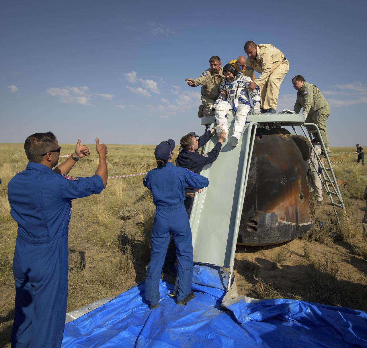 NASA astronaut and Astronaut Office Representative Joe Acaba gives a thumbs up as Expedition 59 NASA astronaut Anne McClain is helped out of the Soyuz MS-11 spacecraft just minutes after she, Canadian Space Agency astronaut David Saint-Jacques, and Roscosmos cosmonaut Oleg Kononenko, landed in a remote area near the town of Zhezkazgan, Kazakhstan on Tuesday, June 25, 2019 Kazakh time (June 24 Eastern time). McClain, Saint-Jacques, and Kononenko are returning after 204 days in space where they served as members of the Expedition 58 and 59 crews onboard the International Space Station. Photo Credit: (NASA/Bill Ingalls)