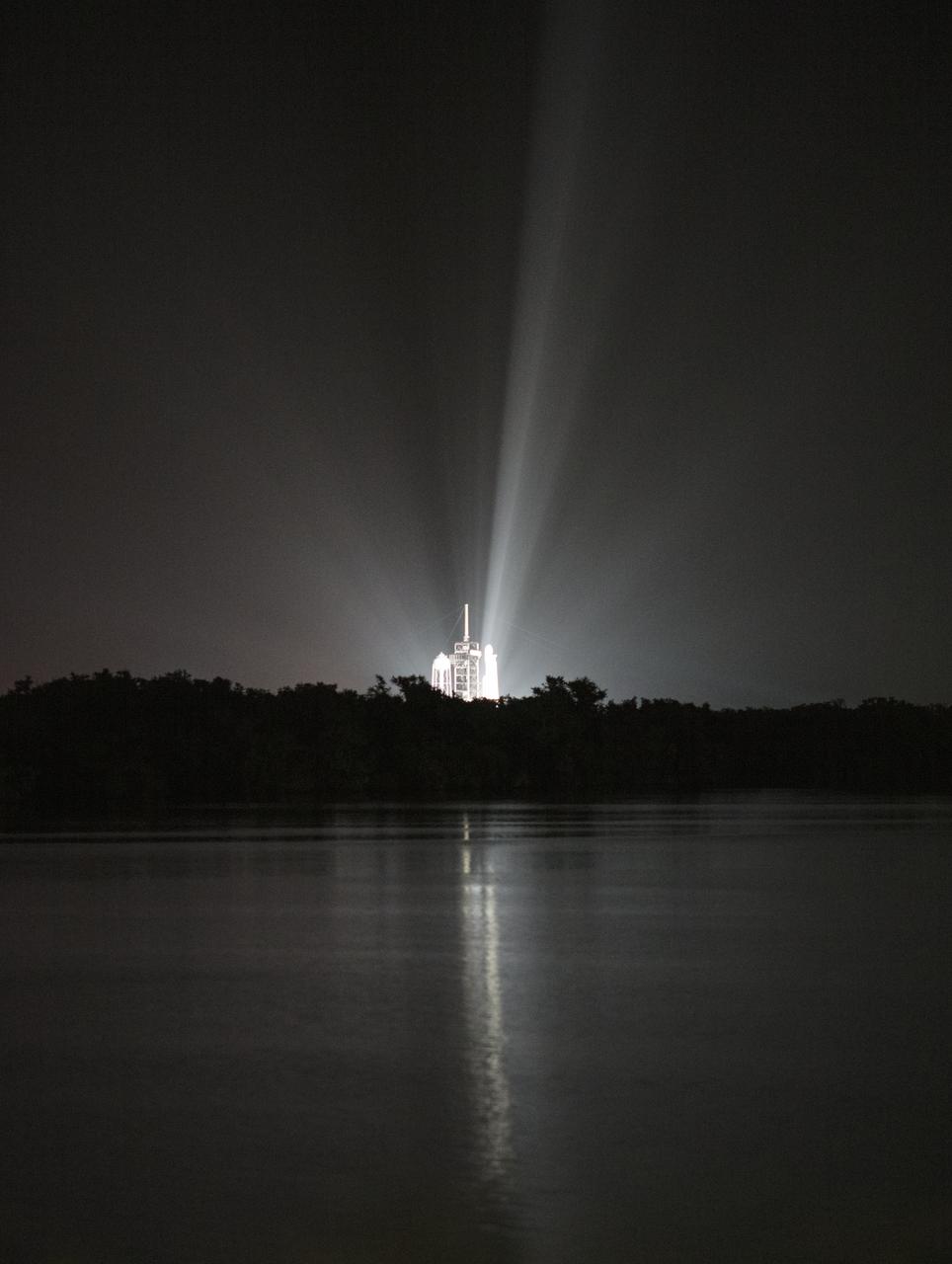A SpaceX Falcon Heavy rocket carrying 24 satellites as part of the Department of Defense's Space Test Program-2 (STP-2) mission is seen illuminated by lights at Launch Complex 39A, Tuesday, June 25, 2019 at NASA's Kennedy Space Center in Florida. Four NASA technology and science payloads which will study non-toxic spacecraft fuel, deep space navigation, "bubbles" in the electrically-charged layers of Earth's upper atmosphere, and radiation protection for satellites are among the two dozen satellites that will be put into orbit. Photo Credit: (NASA/Joel Kowsky)