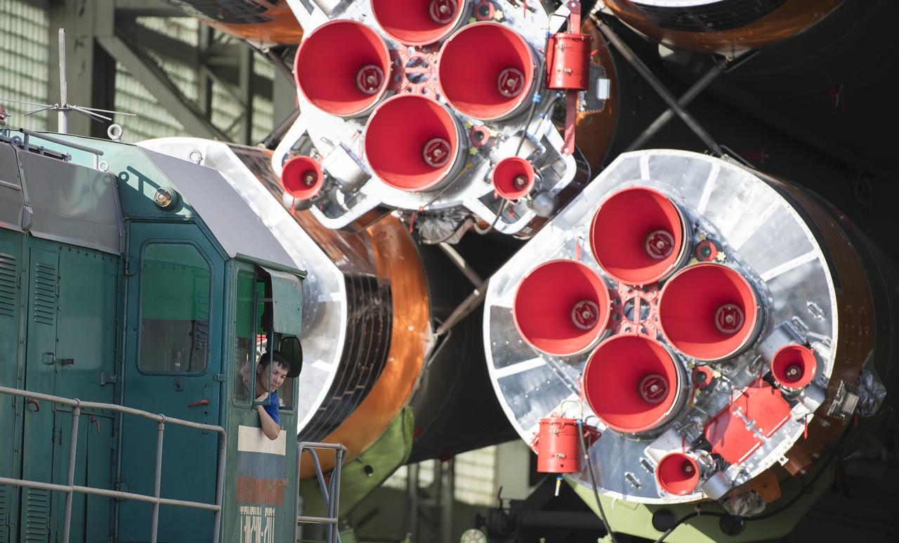 A worker leans out of the cab of the locomotive as it pulls the Soyuz rocket out of Building 112, Thursday, July 18, 2019 at the Baikonur Cosmodrome in Kazakhstan. Expedition 60 Soyuz Commander Alexander Skvortsov of Roscosmos, flight engineer Andrew Morgan of NASA, and flight engineer Luca Parmitano of ESA (European Space Agency) are scheduled to launch aboard their Soyuz MS-13 spacecraft at 12:28 p.m. Eastern time (9:28 p.m. Baikonur time) , on Saturday, July 20. Photo Credit: (NASA/Joel Kowsky)