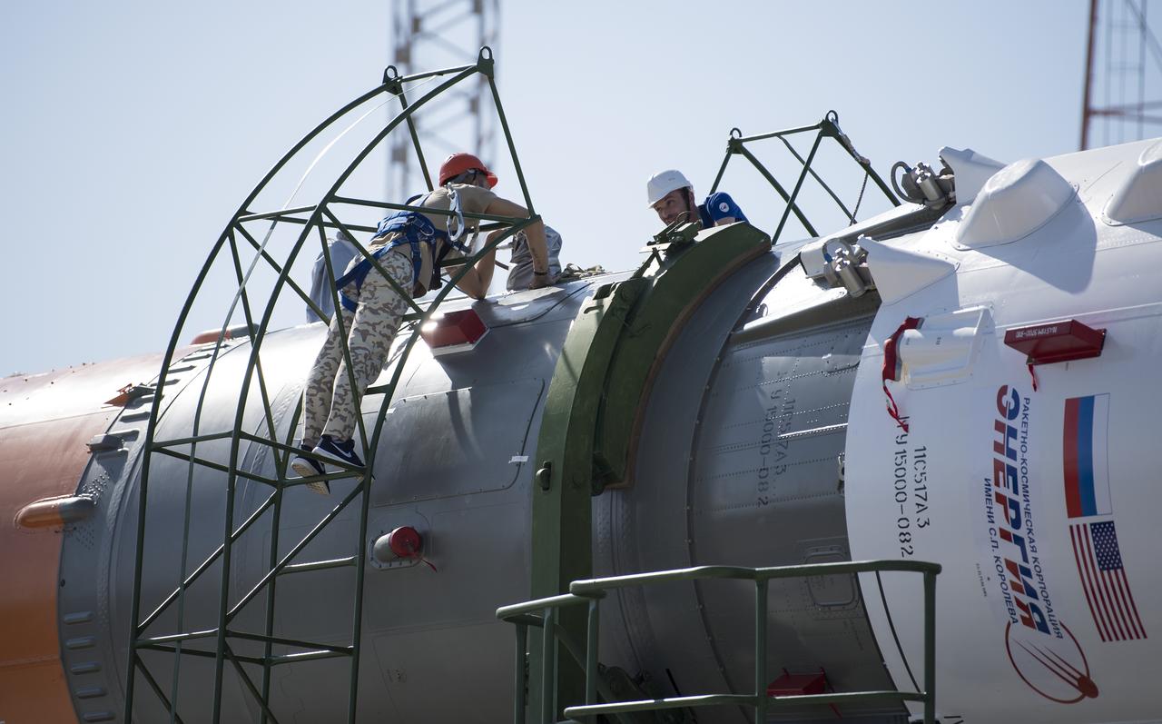 Workers are seen as they prepare the Soyuz rocket to be raised into a vertical position at the launch pad, Thursday, July 18, 2019 at the Baikonur Cosmodrome in Kazakhstan. Expedition 60 Soyuz Commander Alexander Skvortsov of Roscosmos, flight engineer Andrew Morgan of NASA, and flight engineer Luca Parmitano of ESA (European Space Agency) are scheduled to launch aboard their Soyuz MS-13 spacecraft at 12:28 p.m. Eastern time (9:28 p.m. Baikonur time) , on Saturday, July 20. Photo Credit: (NASA/Joel Kowsky)