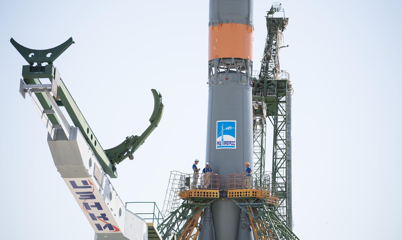 Workers are seen on a gantry after the Soyuz rocket was raised into a vertical position on the launch pad, Thursday, July 18, 2019 at the Baikonur Cosmodrome in Kazakhstan. Expedition 60 Soyuz Commander Alexander Skvortsov of Roscosmos, flight engineer Andrew Morgan of NASA, and flight engineer Luca Parmitano of ESA (European Space Agency) are scheduled to launch aboard their Soyuz MS-13 spacecraft at 12:28 p.m. Eastern time (9:28 p.m. Baikonur time), on Saturday, July 20. Photo Credit: (NASA/Joel Kowsky)