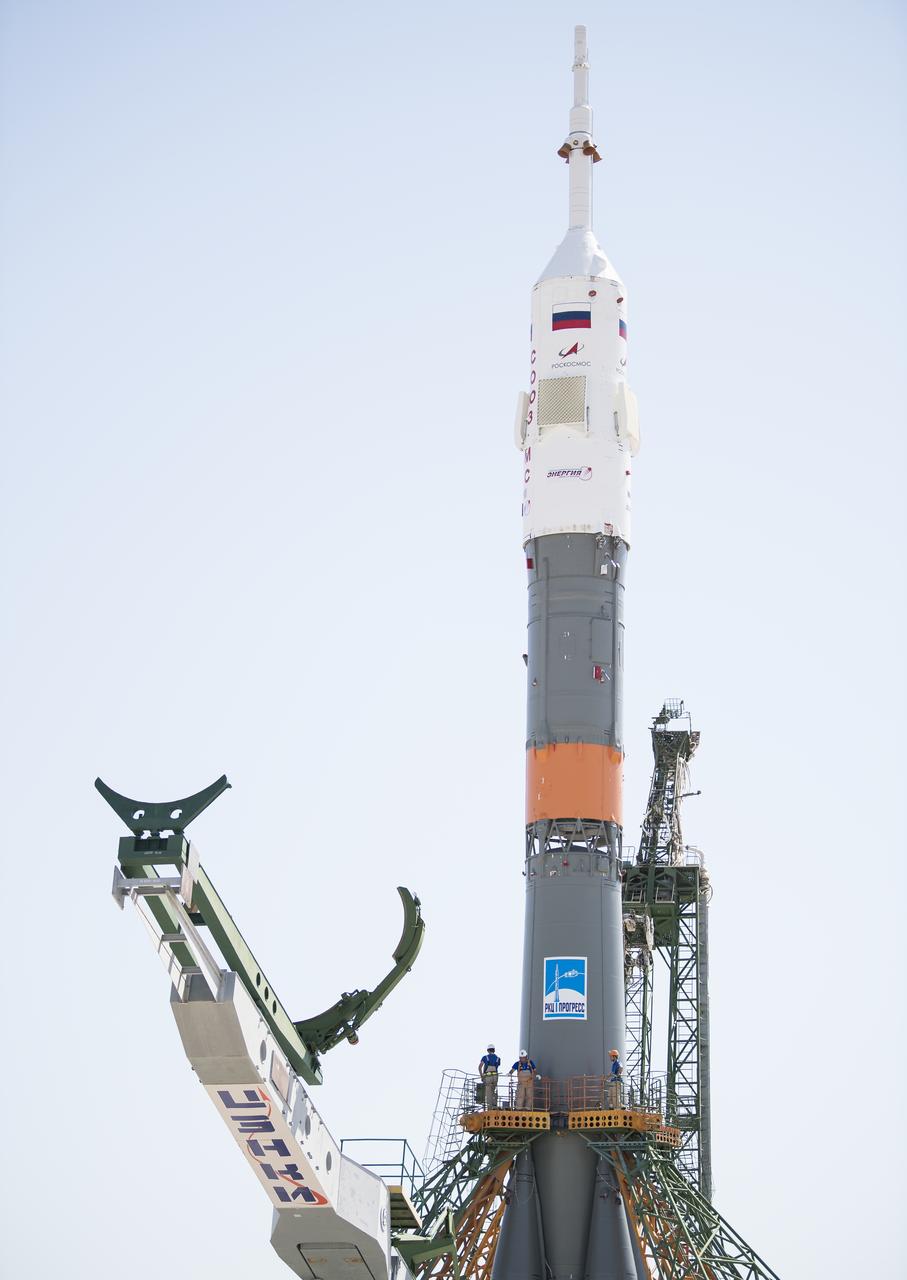 Workers are seen on a gantry after the Soyuz rocket was raised into a vertical position on the launch pad, Thursday, July 18, 2019 at the Baikonur Cosmodrome in Kazakhstan. Expedition 60 Soyuz Commander Alexander Skvortsov of Roscosmos, flight engineer Andrew Morgan of NASA, and flight engineer Luca Parmitano of ESA (European Space Agency) are scheduled to launch aboard their Soyuz MS-13 spacecraft at 12:28 p.m. Eastern time (9:28 p.m. Baikonur time) , on Saturday, July 20. Photo Credit: (NASA/Joel Kowsky)