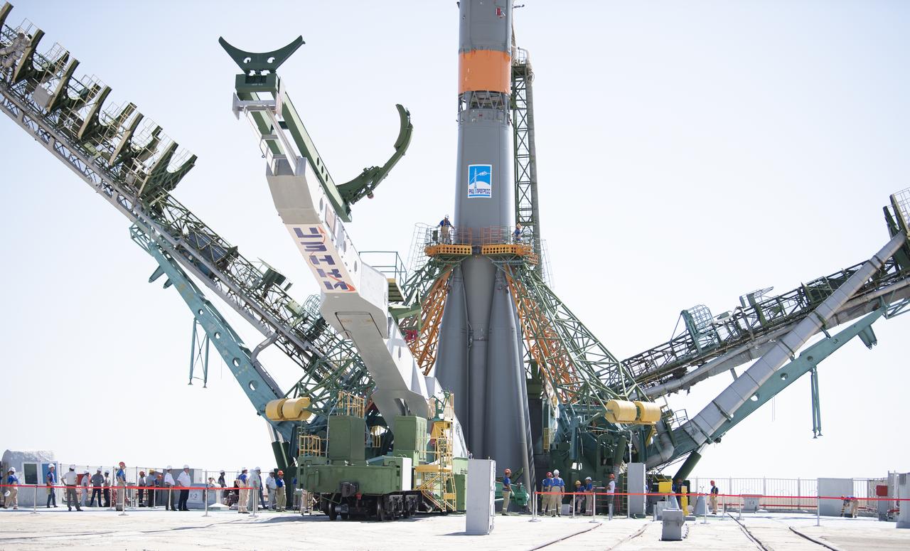 Workers are seen on a gantry after the Soyuz rocket was raised into a vertical position on the launch pad, Thursday, July 18, 2019 at the Baikonur Cosmodrome in Kazakhstan. Expedition 60 Soyuz Commander Alexander Skvortsov of Roscosmos, flight engineer Andrew Morgan of NASA, and flight engineer Luca Parmitano of ESA (European Space Agency) are scheduled to launch aboard their Soyuz MS-13 spacecraft at 12:28 p.m. Eastern time (9:28 p.m. Baikonur time) , on Saturday, July 20. Photo Credit: (NASA/Joel Kowsky)