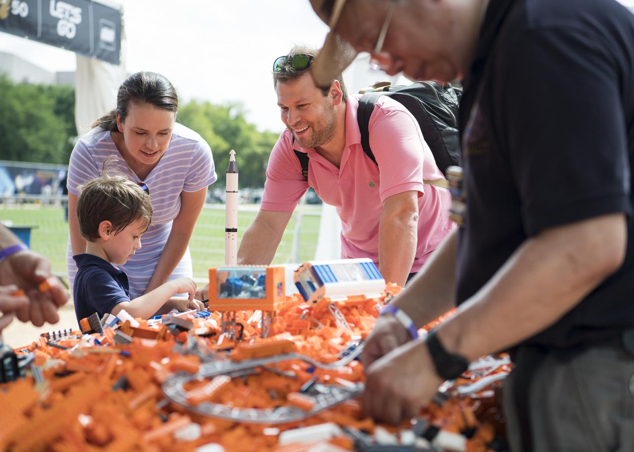 Visitors explore the LEGO exhibit at the Apollo 11 50th Anniversary celebration on the National Mall, Thursday, July 18, 2019 in Washington. Apollo 11 was the first mission to land astronauts on the Moon and launched on July 16, 1969 with astronauts Neil Armstrong, Michael Collins, and Buzz Aldrin. Photo Credit: (NASA/Aubrey Gemignani)