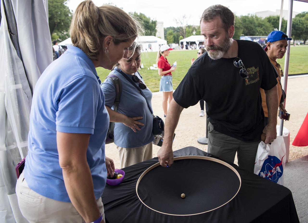 A visitor explores the exhibit at the Apollo 11 50th Anniversary celebration on the National Mall, Thursday, July 18, 2019 in Washington. Apollo 11 was the first mission to land astronauts on the Moon and launched on July 16, 1969 with astronauts Neil Armstrong, Michael Collins, and Buzz Aldrin. Photo Credit: (NASA/Aubrey Gemignani)