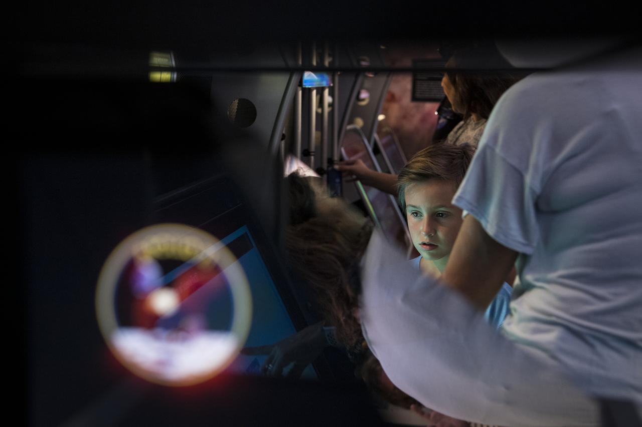 A visitor explores the Journey to Tomorrow exhibit at the Apollo 11 50th Anniversary celebration on the National Mall, Thursday, July 18, 2019 in Washington. Apollo 11 was the first mission to land astronauts on the Moon and launched on July 16, 1969 with astronauts Neil Armstrong, Michael Collins, and Buzz Aldrin. Photo Credit: (NASA/Aubrey Gemignani)