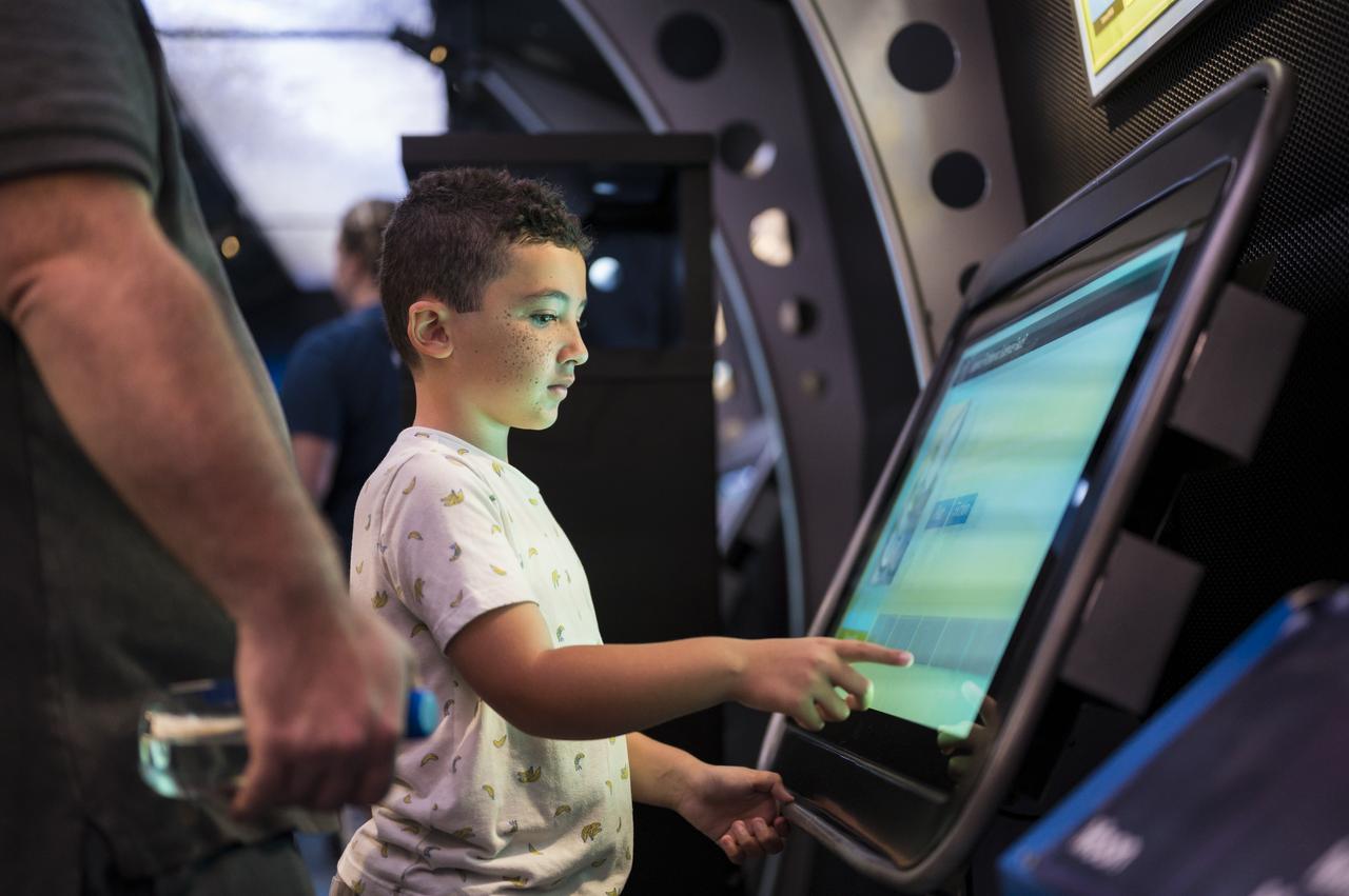 A visitor explores the Journey to Tomorrow exhibit at the Apollo 11 50th Anniversary celebration on the National Mall, Thursday, July 18, 2019 in Washington. Apollo 11 was the first mission to land astronauts on the Moon and launched on July 16, 1969 with astronauts Neil Armstrong, Michael Collins, and Buzz Aldrin. Photo Credit: (NASA/Aubrey Gemignani)