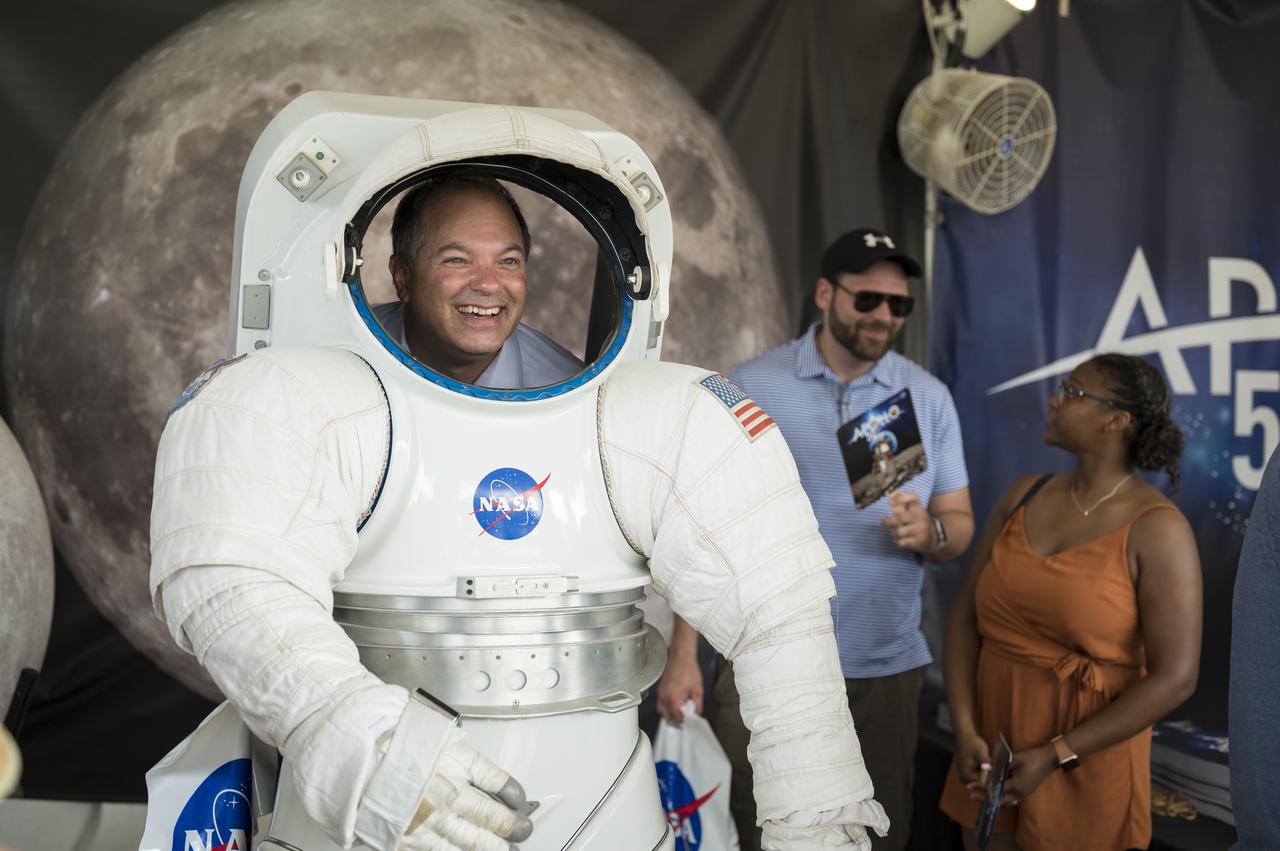 A visitor poses for a photo in the NASA spacesuit at the Apollo 11 50th Anniversary celebration on the National Mall, Thursday, July 18, 2019 in Washington. Apollo 11 was the first mission to land astronauts on the Moon and launched on July 16, 1969 with astronauts Neil Armstrong, Michael Collins, and Buzz Aldrin. Photo Credit: (NASA/Aubrey Gemignani)