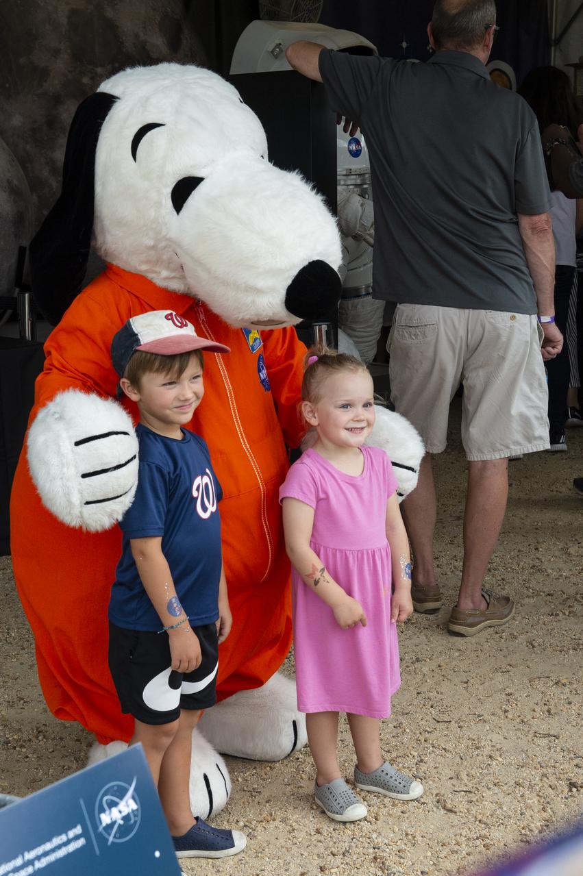 Visitors pose for a photo with Snoopy at the Apollo 11 50th Anniversary celebration on the National Mall, Thursday, July 18, 2019 in Washington. Apollo 11 was the first mission to land astronauts on the Moon and launched on July 16, 1969 with astronauts Neil Armstrong, Michael Collins, and Buzz Aldrin. Photo Credit: (NASA/Connie Moore)