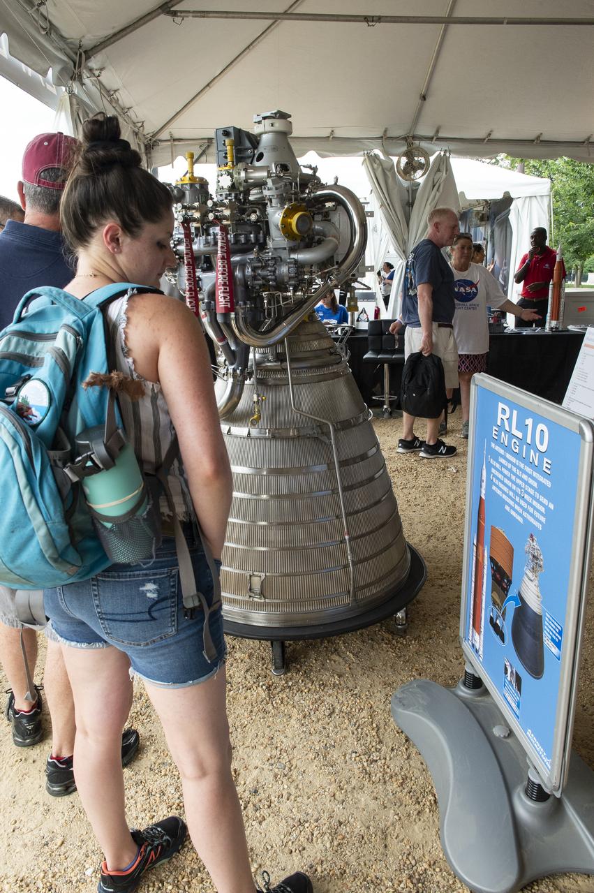A visitor reads about the RL10 engines at the Apollo 11 50th Anniversary celebration on the National Mall, Thursday, July 18, 2019 in Washington. Apollo 11 was the first mission to land astronauts on the Moon and launched on July 16, 1969 with astronauts Neil Armstrong, Michael Collins, and Buzz Aldrin. Photo Credit: (NASA/Connie Moore)