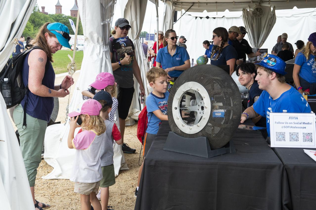 Visitors learn about the SOFIA telescope at the Apollo 11 50th Anniversary celebration on the National Mall, Thursday, July 18, 2019 in Washington. Apollo 11 was the first mission to land astronauts on the Moon and launched on July 16, 1969 with astronauts Neil Armstrong, Michael Collins, and Buzz Aldrin. Photo Credit: (NASA/Connie Moore)