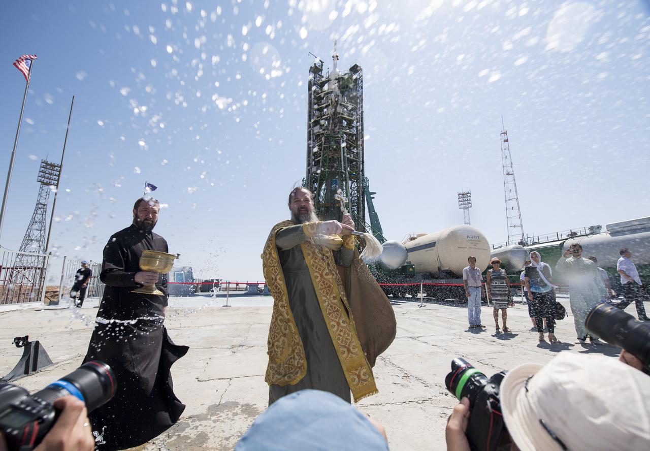 An Orthodox Priest blesses members of the media at the Baikonur Cosmodrome launch pad, Friday, July 19, 2019 in Kazakhstan. Expedition 60 Soyuz Commander Alexander Skvortsov of Roscosmos, flight engineer Andrew Morgan of NASA, and flight engineer Luca Parmitano of ESA (European Space Agency) are scheduled to launch to the International Space Station aboard the Soyuz MS-13 spacecraft on July 20. Photo Credit: (NASA/Joel Kowsky)