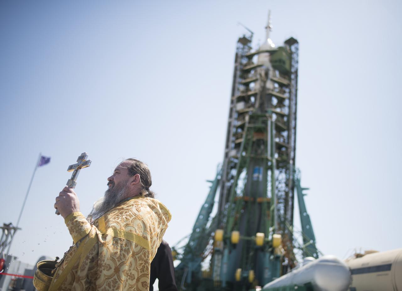 An Orthodox Priest blesses members of the media at the Baikonur Cosmodrome launch pad, Friday, July 19, 2019 in Kazakhstan. Expedition 60 Soyuz Commander Alexander Skvortsov of Roscosmos, flight engineer Andrew Morgan of NASA, and flight engineer Luca Parmitano of ESA (European Space Agency) are scheduled to launch to the International Space Station aboard the Soyuz MS-13 spacecraft on July 20. Photo Credit: (NASA/Joel Kowsky)