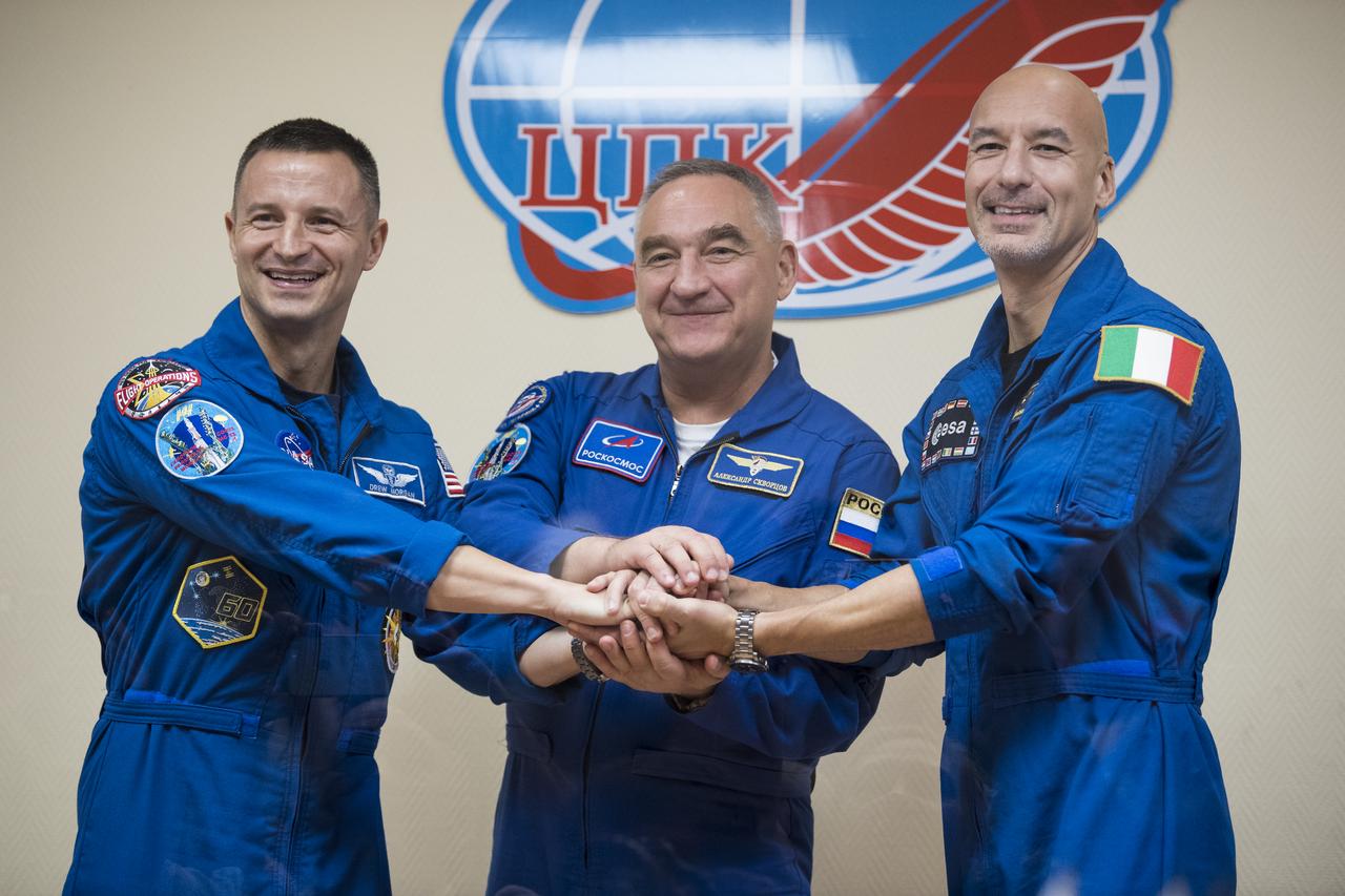 Expedition 60 flight engineer Andrew Morgan of NASA, left, Soyuz Commander Alexander Skvortsov of Roscosmos, center, and flight engineer Luca Parmitano of ESA (European Space Agency), right, pose for a picture at the conclusion of a press conference, Friday, July 19, 2019 at the Cosmonaut Hotel in Baikonur, Kazakhstan. Morgan, Skvortsov, and Parmitano are scheduled to launch to the International Space Station aboard the Soyuz MS-13 spacecraft at 12:28 p.m. Eastern time (9:28 p.m. Baikonur time) on Saturday, July 20. Photo Credit: (NASA/Joel Kowsky)