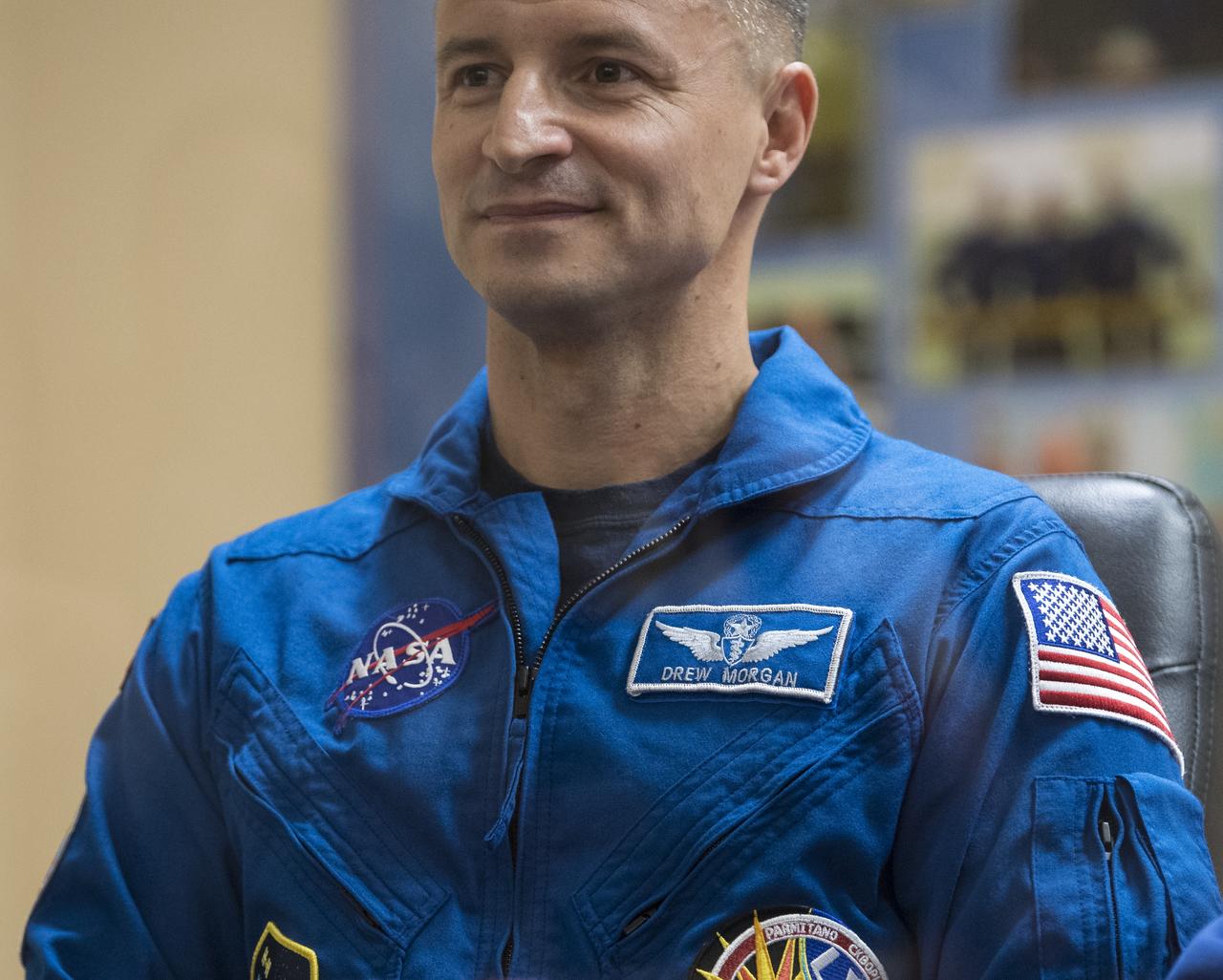 Expedition 60 flight engineer Andrew Morgan of NASA is seen in quarantine, behind glass, during a press conference, Friday, July 19, 2019 at the Cosmonaut Hotel in Baikonur, Kazakhstan. Morgan, Soyuz Commander Alexander Skvortsov of Roscosmos, and flight engineer Luca Parmitano of ESA (European Space Agency) are scheduled to launch to the International Space Station aboard the Soyuz MS-13 spacecraft at 12:28 p.m. Eastern time (9:28 p.m. Baikonur time) on Saturday, July 20. Photo Credit: (NASA/Joel Kowsky)