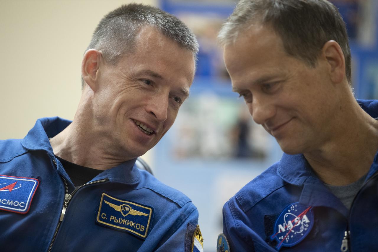 Expedition 60 backup crew members Sergey Ryzhikov of Roscosmos, left, and Thomas Marshburn of NASA, right, are seen in quarantine, behind glass, during a press conference, Friday, July 19, 2019 at the Cosmonaut Hotel in Baikonur, Kazakhstan. Expedition 60 Soyuz Commander Alexander Skvortsov of Roscosmos, flight engineer Andrew Morgan of NASA, and flight engineer Luca Parmitano of ESA (European Space Agency) are scheduled to launch to the International Space Station aboard the Soyuz MS-13 spacecraft at 12:28 p.m. Eastern time (9:28 p.m. Baikonur time) on Saturday, July 20.  Photo Credit: (NASA/Joel Kowsky)