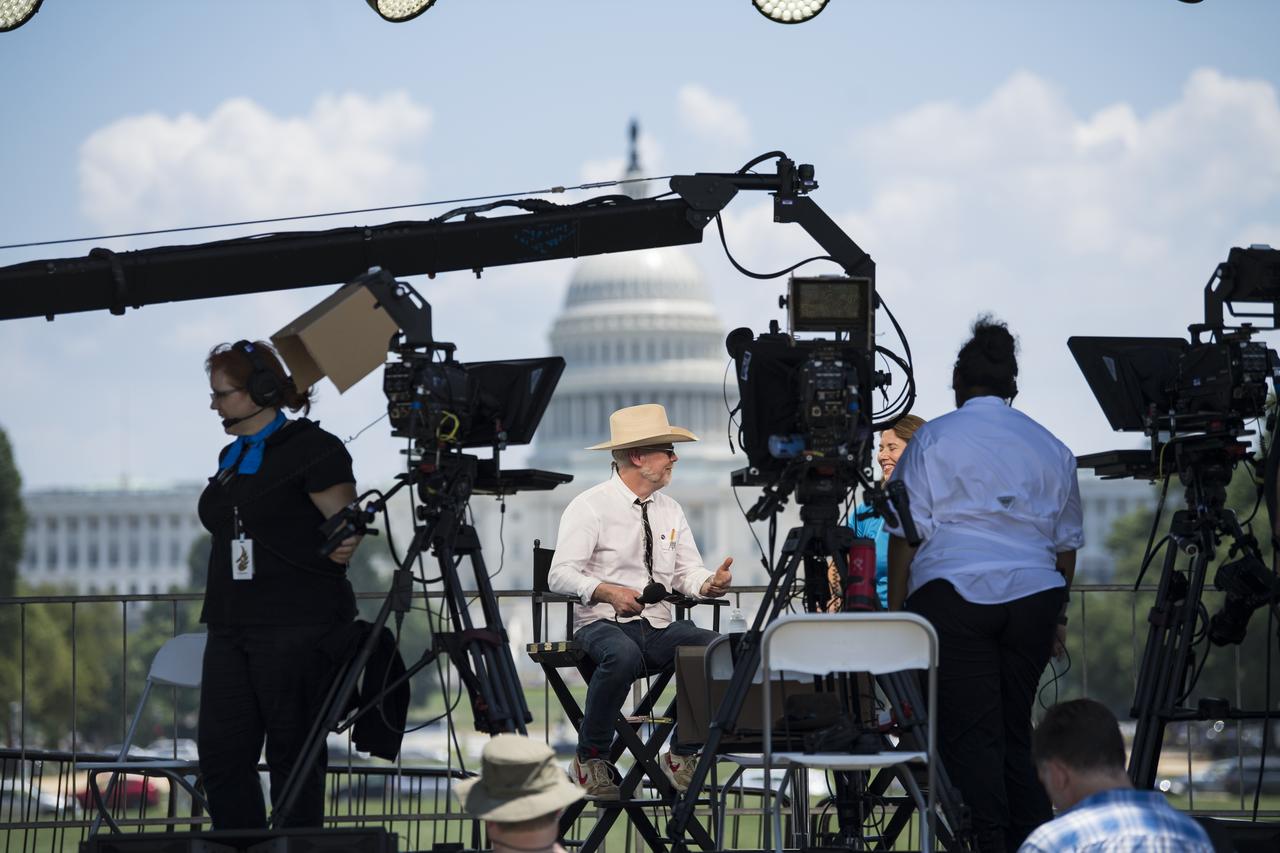 Adam Savage, maker and host of Savage Builds, left, speaks with NASA Public Affairs Officer for Heliophysics, Karen Fox, just before “NASA’s Giant Leaps: Past and Future," a live television program on Friday, July 19, 2019 on the National Mall in Washington. NASA and the world are recognizing the 50th anniversary of Apollo 11, in which astronauts Neil Armstrong, Michael Collins, and Buzz Aldrin crewed the first mission to land astronauts on the Moon. Photo Credit: (NASA/Aubrey Gemignani)