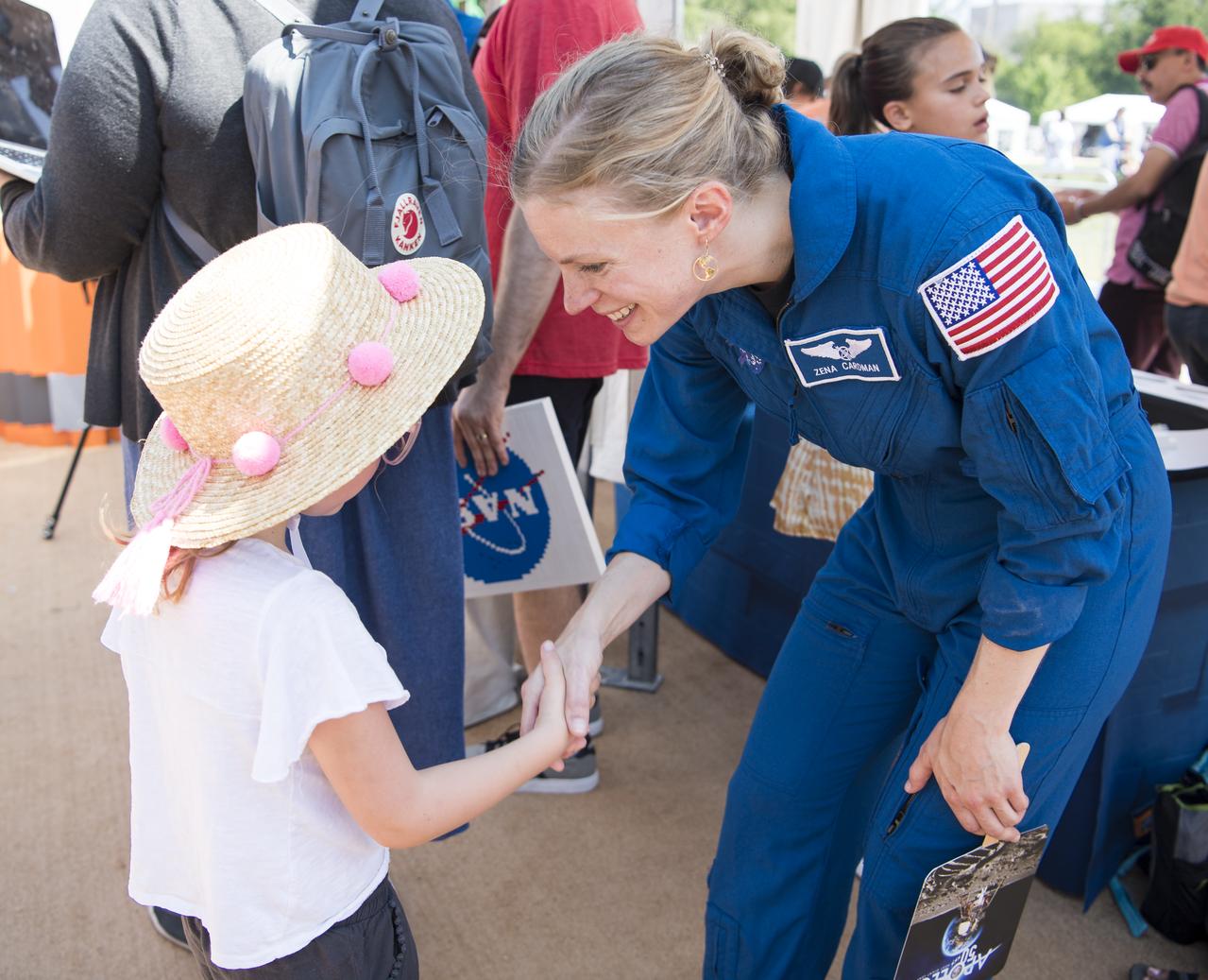 NASA astronaut candidate Zena Cardman greets a visitor at the LEGO exhibit at the Apollo 11 50th Anniversary celebration on the National Mall, Friday, July 19, 2019 in Washington. Apollo 11 was the first mission to land astronauts on the Moon and launched on July 16, 1969 with astronauts Neil Armstrong, Michael Collins, and Buzz Aldrin. Photo Credit: (NASA/Aubrey Gemignani)