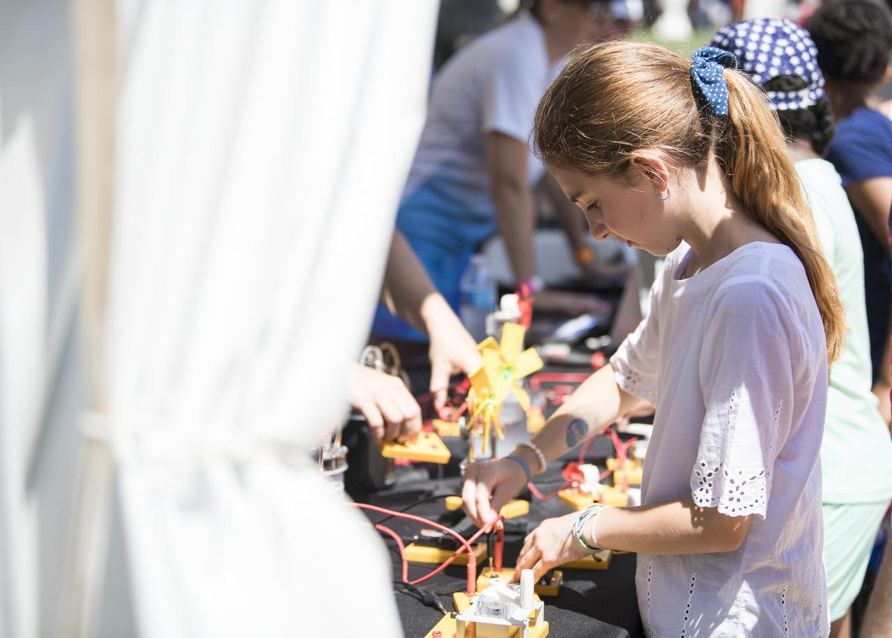 A visitor learns about circuits at the Apollo 11 50th Anniversary celebration on the National Mall, Friday, July 19, 2019 in Washington. Apollo 11 was the first mission to land astronauts on the Moon and launched on July 16, 1969 with astronauts Neil Armstrong, Michael Collins, and Buzz Aldrin. Photo Credit: (NASA/Aubrey Gemignani)