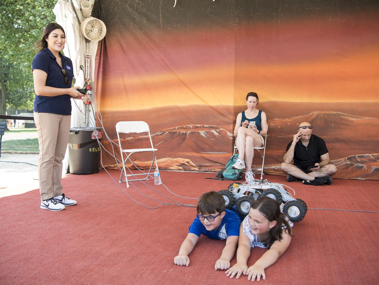 A small rover is driven over some visitors at the Apollo 11 50th Anniversary celebration on the National Mall, Friday, July 19, 2019 in Washington. Apollo 11 was the first mission to land astronauts on the Moon and launched on July 16, 1969 with astronauts Neil Armstrong, Michael Collins, and Buzz Aldrin. Photo Credit: (NASA/Aubrey Gemignani)