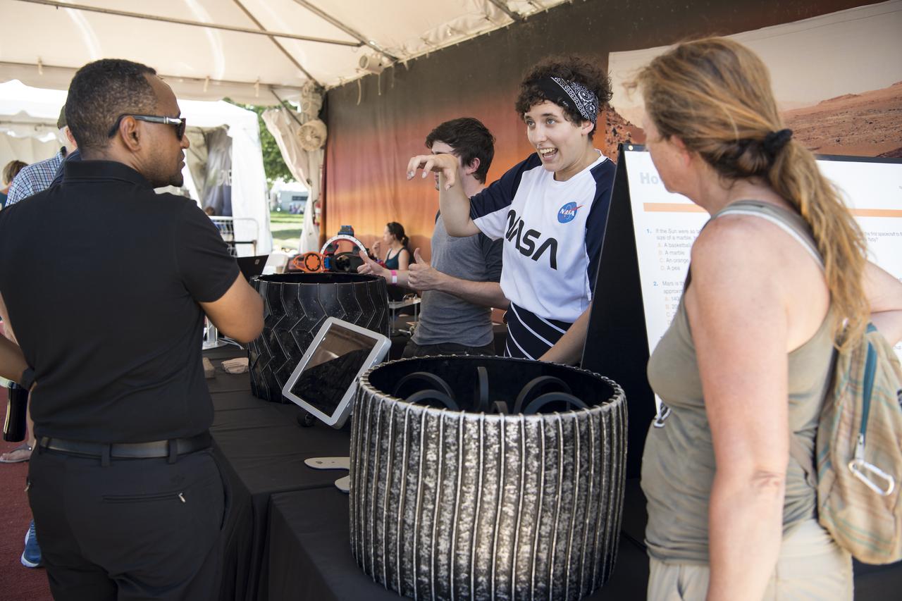 Visitors learn about rover tires at the Apollo 11 50th Anniversary celebration on the National Mall, Friday, July 19, 2019 in Washington. Apollo 11 was the first mission to land astronauts on the Moon and launched on July 16, 1969 with astronauts Neil Armstrong, Michael Collins, and Buzz Aldrin. Photo Credit: (NASA/Aubrey Gemignani)