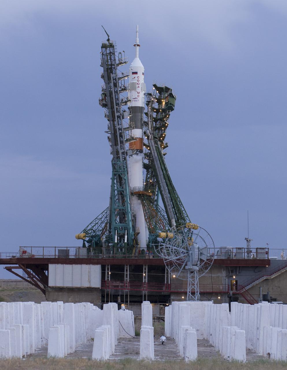 The Soyuz rocket with MS-13 spacecraft onboard is seen on the launch pad as the service structure arms are lowered before launch, Saturday, July 20, 2019 at the Baikonur Cosmodrome in Kazakhstan. Expedition 60 Soyuz Commander Alexander Skvortsov of Roscosmos, flight engineer Andrew Morgan of NASA, and flight engineer Luca Parmitano of ESA (European Space Agency) launched at 12:28 p.m. Eastern time (9:28 p.m. Baikonur time) to begin their mission to the International Space Station. Photo Credit: (NASA/Joel Kowsky)