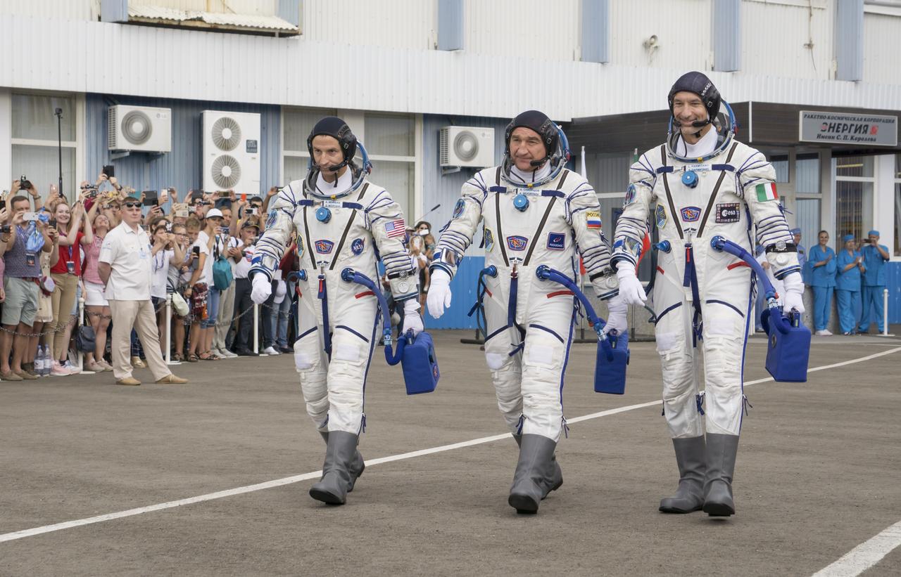 Expedition 60 flight engineer Andrew Morgan of NASA, left, Soyuz Commander Alexander Skvortsov of Roscosmos, center, and flight engineer Luca Parmitano of ESA (European Space Agency), right, are seen as they walk out of Building 254 after donning their Russian Sokol suits, Saturday, July 20, 2019 at the Baikonur Cosmodrome in Kazakhstan. Morgan, Skvortsov, and Parmitano launched aboard the Soyuz MS-13 spacecraft at 12:28 p.m. Eastern time (9:28 p.m. Baikonur time) on July 20 to begin their journey to the International Space Station. Photo Credit: (NASA/Victor Zelentsov)